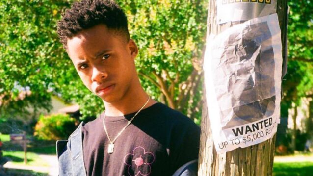 Tay-K poseeraa etsintäkuulutusilmoituksensa edessä.