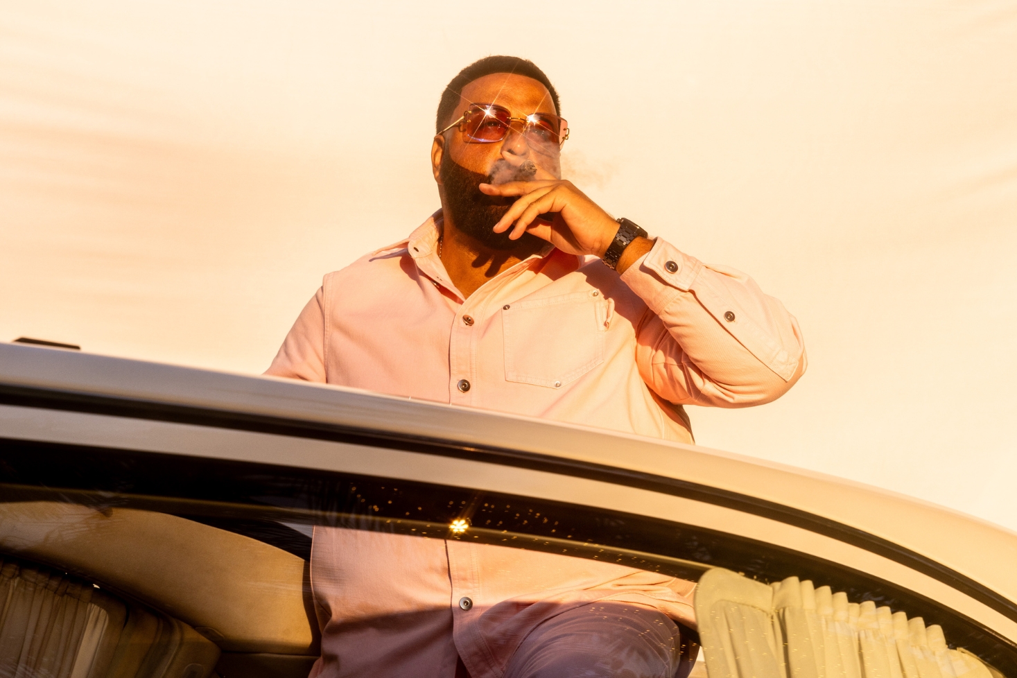 DJ Khaled avoauton päällä istumassa. DJ Khaled isännöi GTA 6:n radiokanavaa!